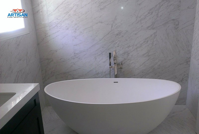 A freestanding tub against marble walls